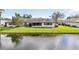 A backyard view features a home with an enclosed patio and a serene lake reflecting the sky at 2022 Heathfield Cir, Sun City Center, FL 33573