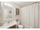 Well-lit bathroom with decorative cabinet and neutral striped shower curtain at 2022 Heathfield Cir, Sun City Center, FL 33573