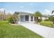 Charming single-story home with a well-manicured lawn, screened entrance, and a freshly painted driveway at 2022 Heathfield Cir, Sun City Center, FL 33573
