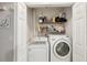 Convenient laundry closet with washer, dryer, and shelving for storage at 2022 Heathfield Cir, Sun City Center, FL 33573