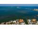 Aerial view of a waterfront house with a bridge in the background and a well manicured neighborhood at 2240 Harbor View Dr, Dunedin, FL 34698