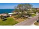 A charming home with a beautiful lawn and mature tree offers a peaceful setting near the water at 2240 Harbor View Dr, Dunedin, FL 34698