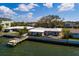 Exterior view of a waterfront home featuring a private pier, screen enclosed porch and mature tree at 2240 Harbor View Dr, Dunedin, FL 34698