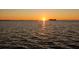 Golden sunset reflecting on tranquil water surface, highlighting the beauty of waterfront living at 2240 Harbor View Dr, Dunedin, FL 34698