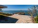 Waterfront backyard view of a wooden pier with a stone patio at 2240 Harbor View Dr, Dunedin, FL 34698