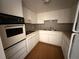 Efficient kitchen with white cabinets, classic appliances, and practical layout at 2449 Columbia Dr # 29, Clearwater, FL 33763