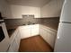 Bright kitchen featuring white cabinetry, functional appliances, and tiled countertops at 2449 Columbia Dr # 29, Clearwater, FL 33763