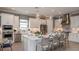 Modern kitchen features white cabinets, stainless steel appliances, a central island, and elegant pendant lighting at 29444 Toricelli Rd, Wesley Chapel, FL 33543