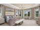 Luxurious main bedroom boasts tray ceilings, large windows, neutral decor, and plush carpeting at 29444 Toricelli Rd, Wesley Chapel, FL 33543