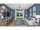 Elegant study featuring paneled blue walls, a decorative light fixture, and expansive views of the lush greenery at 29444 Toricelli Rd, Wesley Chapel, FL 33543
