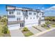 Stunning aerial view of a three-story townhome with private garages, manicured landscaping, and stylish architecture at 3025 Bermuda Sloop Cir, Ruskin, FL 33570