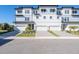 Stylish three-story townhome showcasing individual garages, elegant curb appeal, and modern design at 3025 Bermuda Sloop Cir, Ruskin, FL 33570