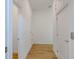Hallway with wood-look tile flooring and white walls, providing access to several rooms at 3025 Bermuda Sloop Cir, Ruskin, FL 33570