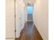 Long hallway featuring hardwood floors, white walls, and entry to stairway and several rooms at 3025 Bermuda Sloop Cir, Ruskin, FL 33570
