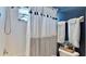 Bright bathroom features a shower with a curtain, white tile, and towel racks for added convenience at 310 Manns Harbor Dr, Apollo Beach, FL 33572