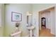 Light and airy powder room with a pedestal sink, decorative mirror, and soft natural light at 310 Manns Harbor Dr, Apollo Beach, FL 33572
