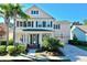 Charming two-story home featuring a manicured front yard, a covered porch, blue shutters, and an attached two-car garage at 310 Manns Harbor Dr, Apollo Beach, FL 33572