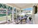 Inviting screened patio featuring a wrought iron dining set and brick flooring at 310 Manns Harbor Dr, Apollo Beach, FL 33572