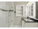 Bathroom featuring tiled shower, stylish vanity, and mirrored cabinet at 3303 W Price Ave, Tampa, FL 33611