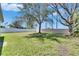 Expansive backyard with healthy green grass, mature shade trees, and a white vinyl privacy fence at 3537 Valencia Cove Court, Land O Lakes, FL 34639