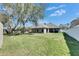 Backyard featuring green grass, mature trees, and a patio area perfect for outdoor entertainment at 3537 Valencia Cove Court, Land O Lakes, FL 34639