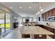 Open-concept kitchen boasts granite countertops, stainless steel appliances, and a seamless transition to the outdoor living space at 3537 Valencia Cove Court, Land O Lakes, FL 34639