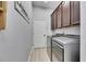 Laundry room with modern appliances, upper cabinets for storage and tile floors at 3537 Valencia Cove Court, Land O Lakes, FL 34639