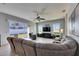 Comfortable living room with a ceiling fan, large windows overlooking the backyard, and a plush sectional sofa at 3537 Valencia Cove Court, Land O Lakes, FL 34639