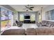 Bright living room features large windows, a ceiling fan, and a comfortable sectional sofa for relaxation at 3537 Valencia Cove Court, Land O Lakes, FL 34639