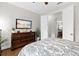 Comfortable bedroom with hardwood floors, a large dresser with a TV, and an ensuite bathroom at 3605 E Tampa Cir, Tampa, FL 33629