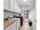 Well-organized laundry room with white cabinets and modern red washer and dryer at 3605 E Tampa Cir, Tampa, FL 33629