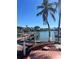 Waterfront backyard featuring a private wooden dock with boating access, enhanced by swaying palm trees at 3800 Belle Vista E Dr, St Pete Beach, FL 33706