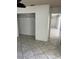A bedroom featuring neutral tile flooring and an open closet with ample storage space at 3800 Belle Vista E Dr, St Pete Beach, FL 33706