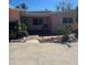 Charming single-story home with a vibrant pink exterior, front yard landscaping, and brick walkway at 3800 Belle Vista E Dr, St Pete Beach, FL 33706