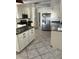 Well-equipped kitchen featuring granite countertops, white cabinetry, and stainless steel appliances, offering ample storage and style at 3800 Belle Vista E Dr, St Pete Beach, FL 33706