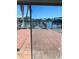 Patio view showcases waterfront scenery with damaged dock, reflected in sliding glass doors at 3800 Belle Vista E Dr, St Pete Beach, FL 33706