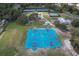 Aerial view of a blue outdoor basketball court surrounded by tennis courts and greenery in a community park at 4614 River Overlook Dr, Valrico, FL 33596