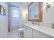 A well-lit bathroom with a white vanity, a large mirror, and a shower over the tub at 4614 River Overlook Dr, Valrico, FL 33596