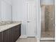 Bathroom featuring a gray vanity with a granite countertop and a glass-enclosed shower with decorative tile at 4810 W Mcelroy Ave # 7, Tampa, FL 33611