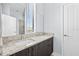 Bright bathroom featuring a double vanity with granite countertop, and ample natural light from a window at 4810 W Mcelroy Ave # 7, Tampa, FL 33611