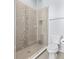 Modern glass shower with decorative tiles, a built-in niche, and a toilet in a well-lit bathroom at 4810 W Mcelroy Ave # 7, Tampa, FL 33611