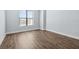 An empty bedroom with wood-look floors and a window offers a clean, bright space at 4810 W Mcelroy Ave # 7, Tampa, FL 33611