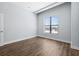 Large empty bedroom with wood-look floors, baseboards, and a window with blinds at 4810 W Mcelroy Ave # 7, Tampa, FL 33611