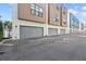 Modern townhome row featuring two-car garages, neutral exteriors, sidewalks, and landscaping at 4810 W Mcelroy Ave # 7, Tampa, FL 33611