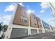 Modern townhome row featuring two-car garages, neutral exteriors and ample natural light against blue sky at 4810 W Mcelroy Ave # 7, Tampa, FL 33611