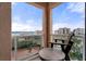 Relaxing balcony with a view of the water, tennis courts and a comfortable chair and table set at 4951 Bacopa S Ln # 801, St Petersburg, FL 33715