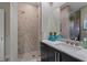 Bathroom featuring a glass-enclosed shower, dark wood vanity, quartz countertop, and modern fixtures at 4951 Bacopa S Ln # 801, St Petersburg, FL 33715