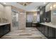 Modern bathroom with a spacious shower, dual vanities, and stylish wood-look tile flooring at 4951 Bacopa S Ln # 801, St Petersburg, FL 33715