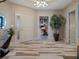 Inviting foyer featuring wood-look tile flooring, an elegant light fixture, and a glimpse of the home office at 4951 Bacopa S Ln # 801, St Petersburg, FL 33715