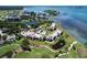 Stunning aerial view of waterfront condos surrounded by lush greenery, a pool, and serene water features at 50 Coe Rd # 223, Belleair, FL 33756
